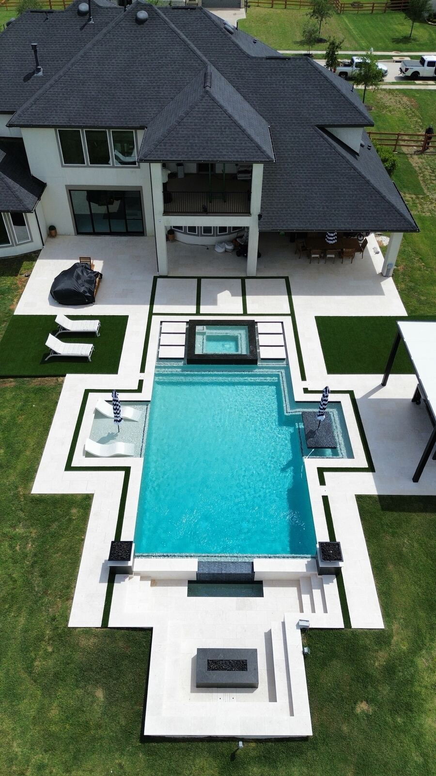 Vertical aerial view of a modern pool with black deck accents