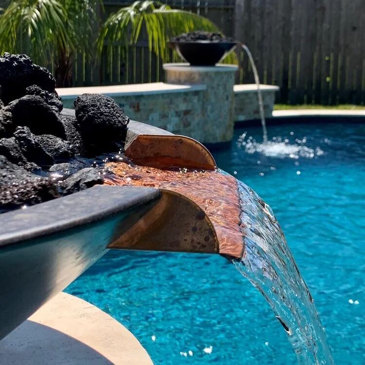 Close-up of a copper spillway and lava-rock fire bowl