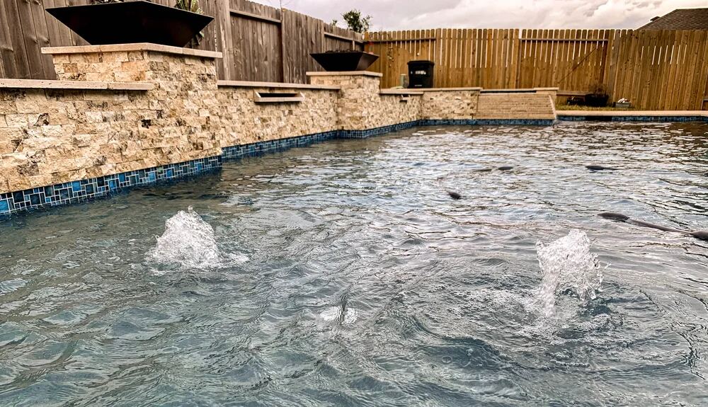 Pool with raised spa fountain and travertine surround