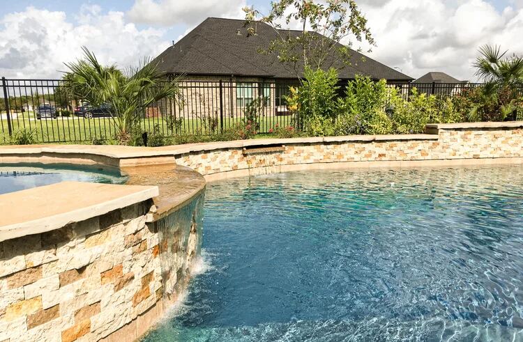 Pool corner with stone accent wall and iron fencing