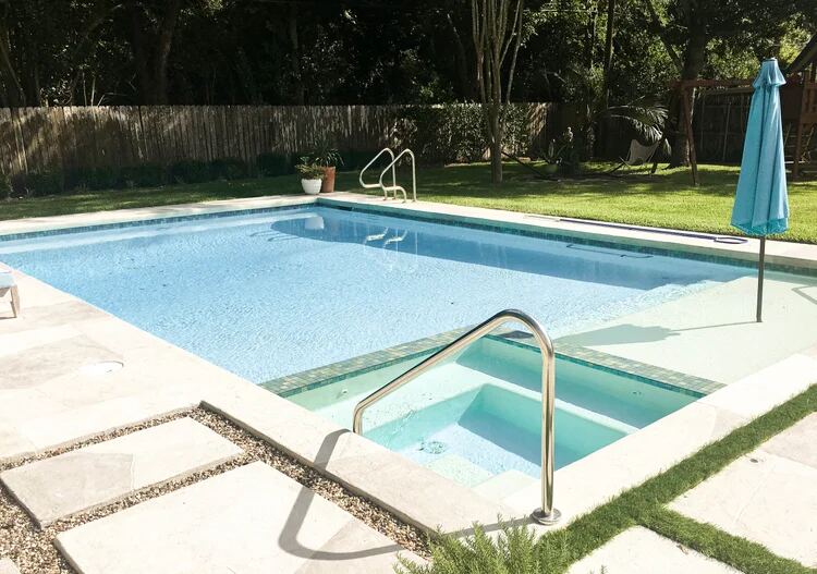Shaded rectangular pool with stainless steel handrails