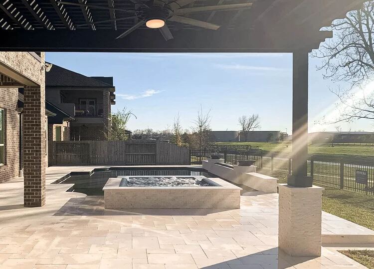 Rectangular pool with umbrella and raised spa in a shaded yard