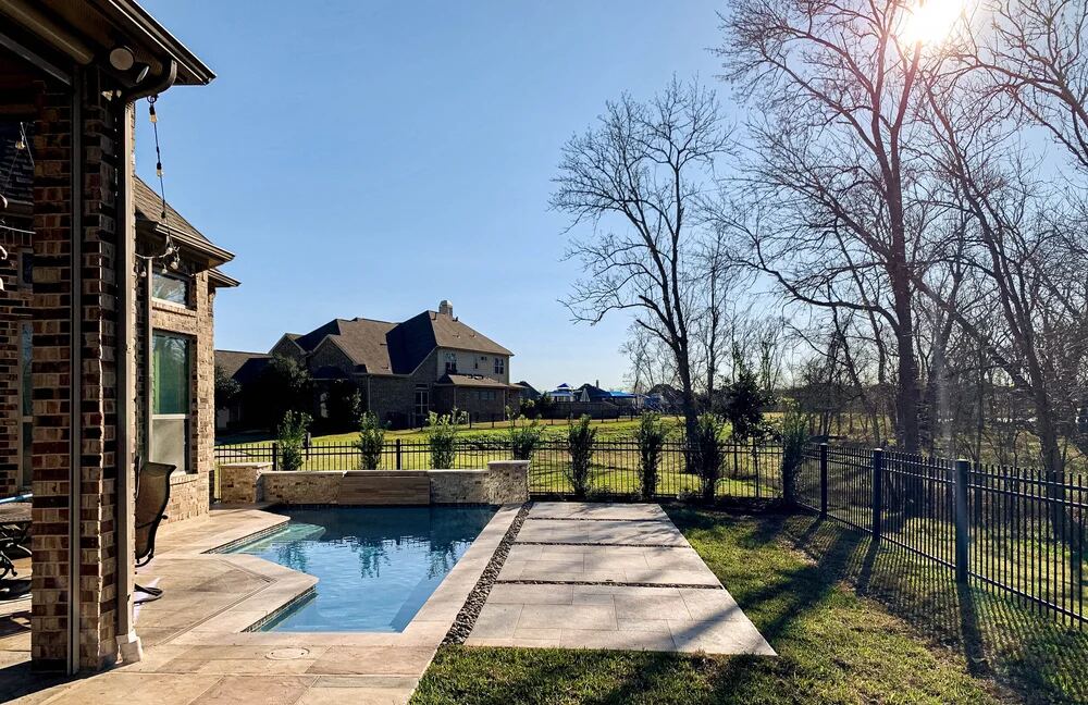 Rectangular pool with stainless rails and steps beneath mature trees