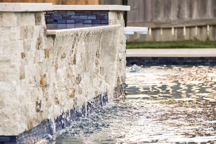 Close-up of a blue-tile waterfall spillway glowing at sunset